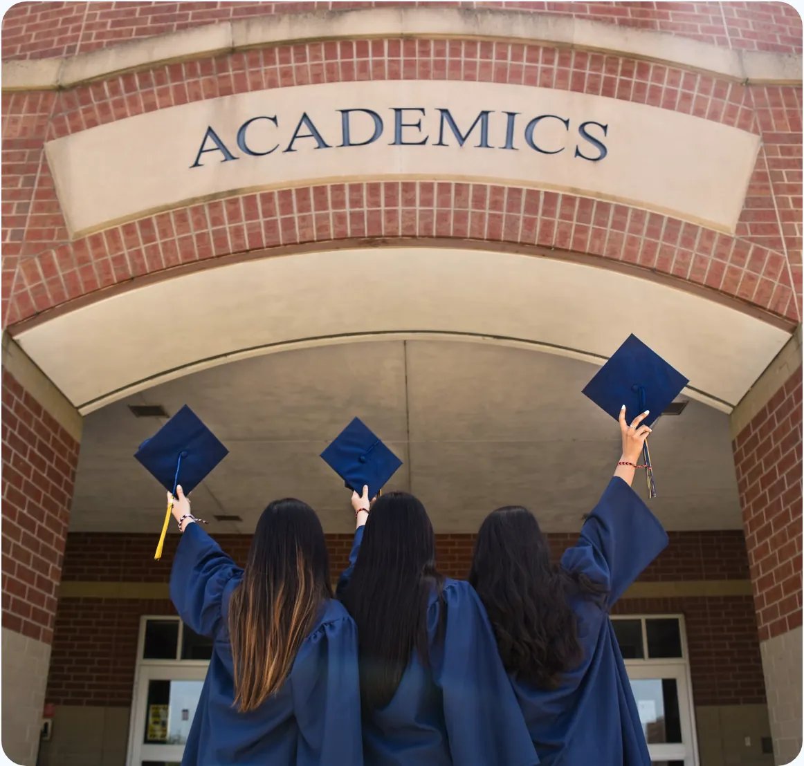 College graduates celebrating outside an academics building