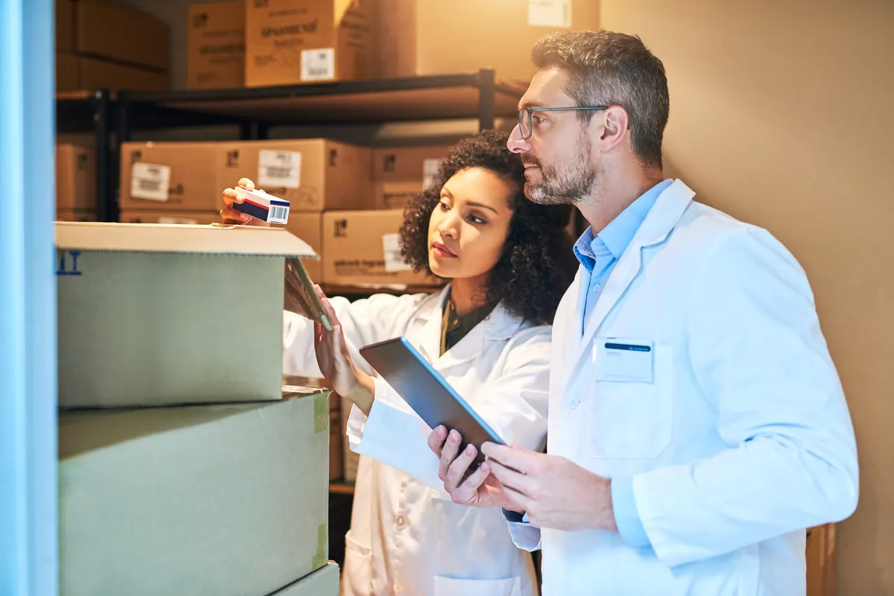 Distribution team checking medical supply inventory on a tablet